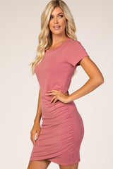 woman wearing a pink short sleeve bodycon dress with ruched side detail