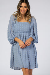 woman wearing a light blue short dress with a smocked bodice and puff sleeves, featuring 3D floral embellishments