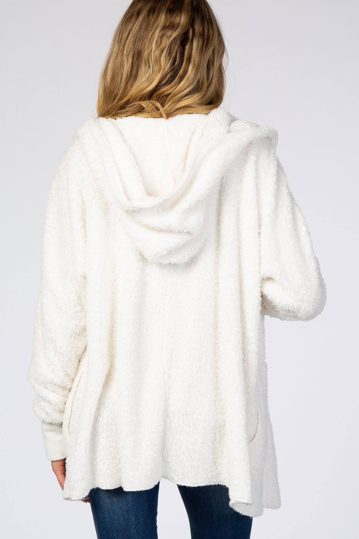 woman wearing a soft white furry maternity hoodie, showing the back view