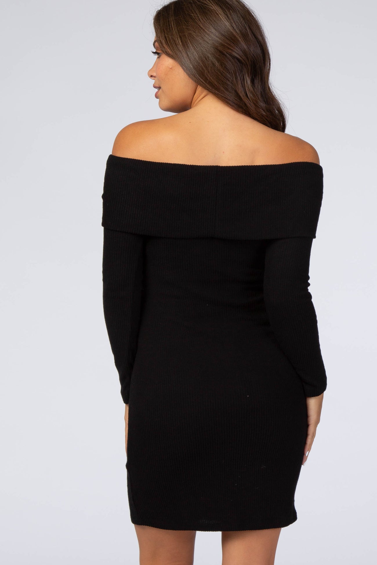 back view of a woman wearing a black off-the-shoulder long sleeve ribbed mini dress