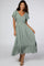 woman wearing a green v-neck midi dress with flutter sleeves and a tiered hem