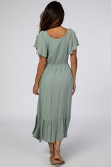 woman wearing a sage green short sleeve maxi dress with a tiered skirt and smocked bodice, shown from the back