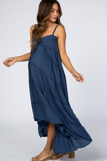 pregnant woman wearing a navy blue tiered maternity maxi dress with spaghetti straps and tan block heels