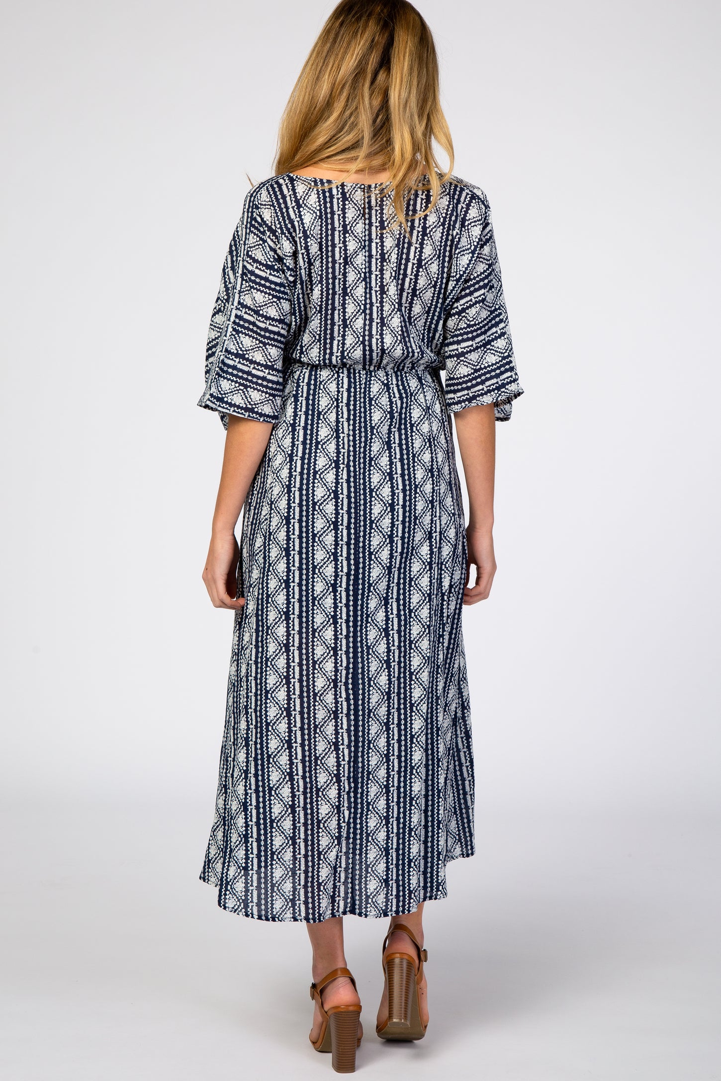 woman wearing a navy blue and white patterned maternity maxi dress with loose sleeves, shown from the back