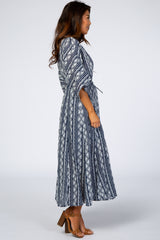 woman wearing a navy blue patterned maxi dress with a tie waist and flutter sleeves