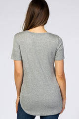 woman wearing a light grey short sleeve maternity top with a rounded hemline, showing a smooth back view