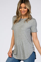 woman wearing a grey short sleeve ribbed knit top with a curved hem and blue jeans
