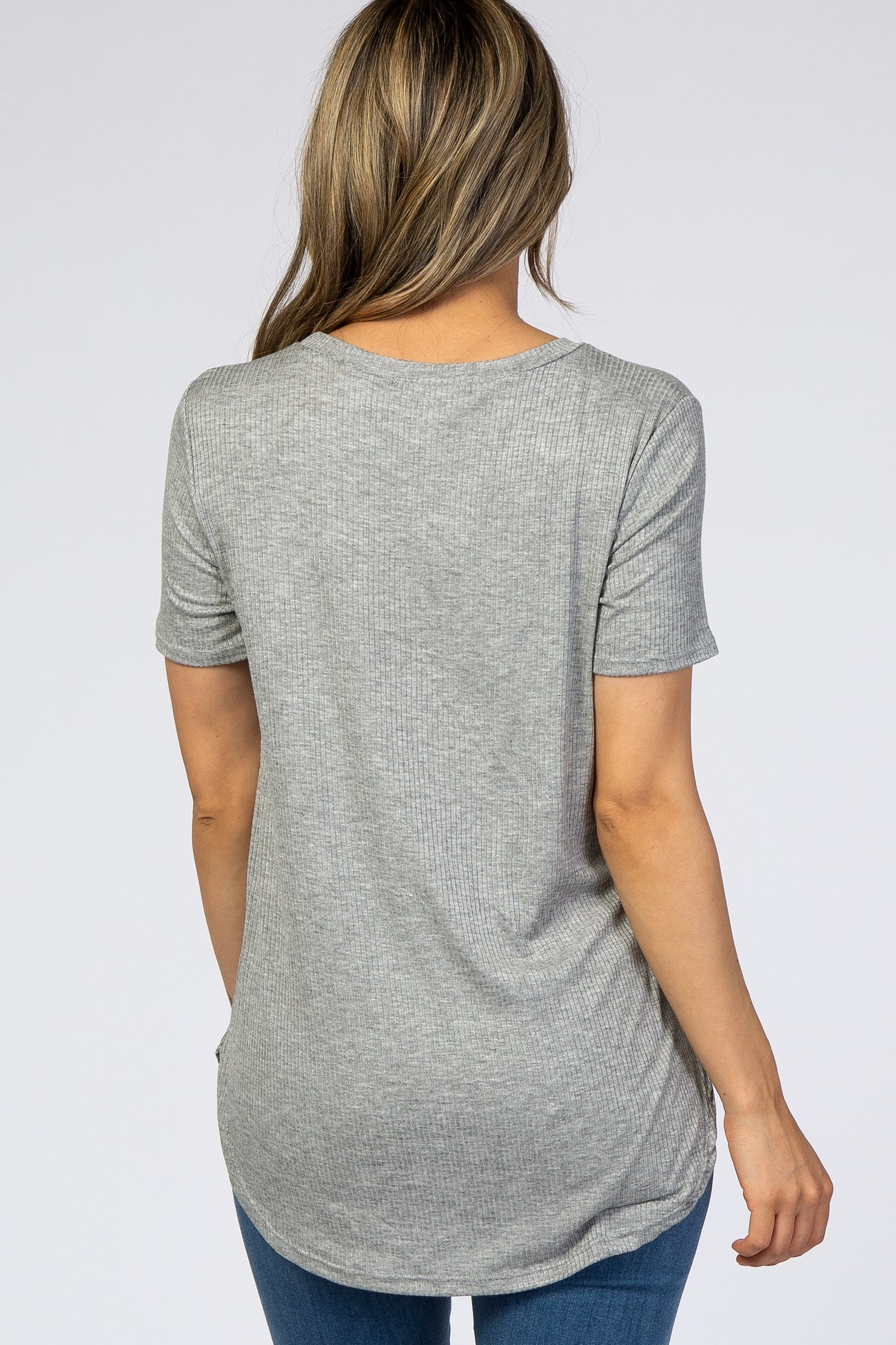 woman wearing a light grey ribbed short sleeve top with a rounded hem and back view showing relaxed fit
