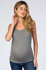 woman wearing a gray ribbed maternity tank top and showing her baby bump while posing thoughtfully