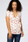 woman wearing a white floral short sleeve wrap maternity top with red flowers and blue jeans