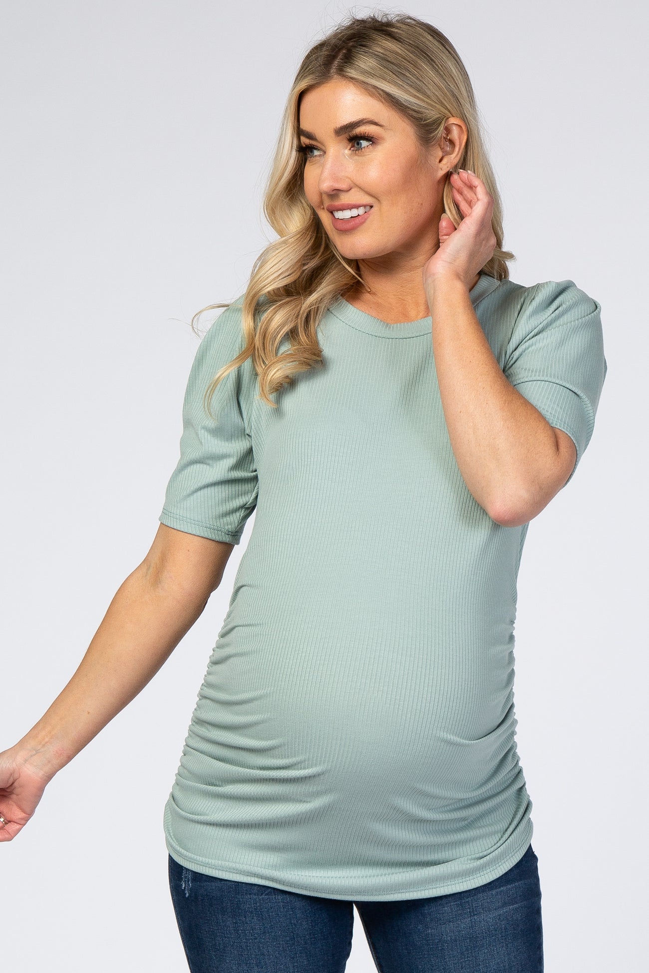 blonde woman wearing a sage green ribbed maternity top with short puff sleeves and side ruching
