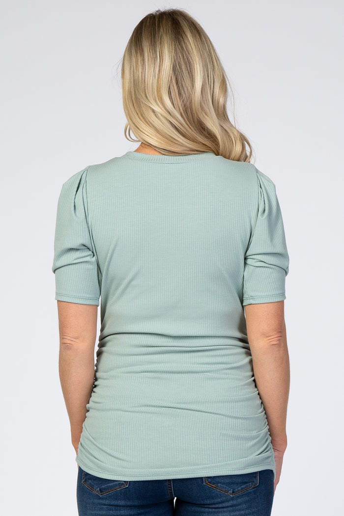 Back view of a woman wearing a sage green ribbed short sleeve maternity top with puffed shoulders and side ruching
