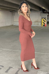 woman in a long sleeve ribbed knit midi dress in rust brown with matching high heel pumps in a parking garage