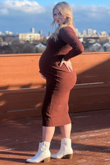 woman wearing a rust ribbed maternity dress showcasing her baby bump and styled with white ankle boots
