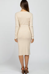 woman wearing a beige ribbed maternity dress with long sleeves and a fitted silhouette, showing her back