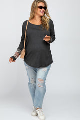 woman wearing a dark grey maternity plus long sleeve top with floral print sleeves and distressed light blue jeans