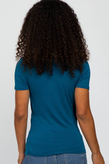 woman wearing a teal short sleeve fitted top, viewed from the back