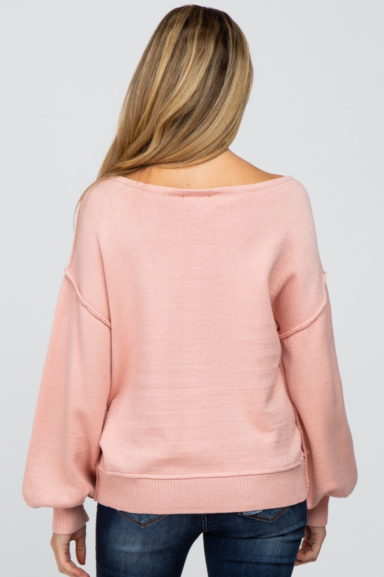 woman wearing a soft pink maternity sweater with a relaxed fit and balloon sleeves, shown from the back