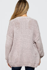 woman wearing a light pink oversized knitted maternity sweater with a loose fit, shown from the back