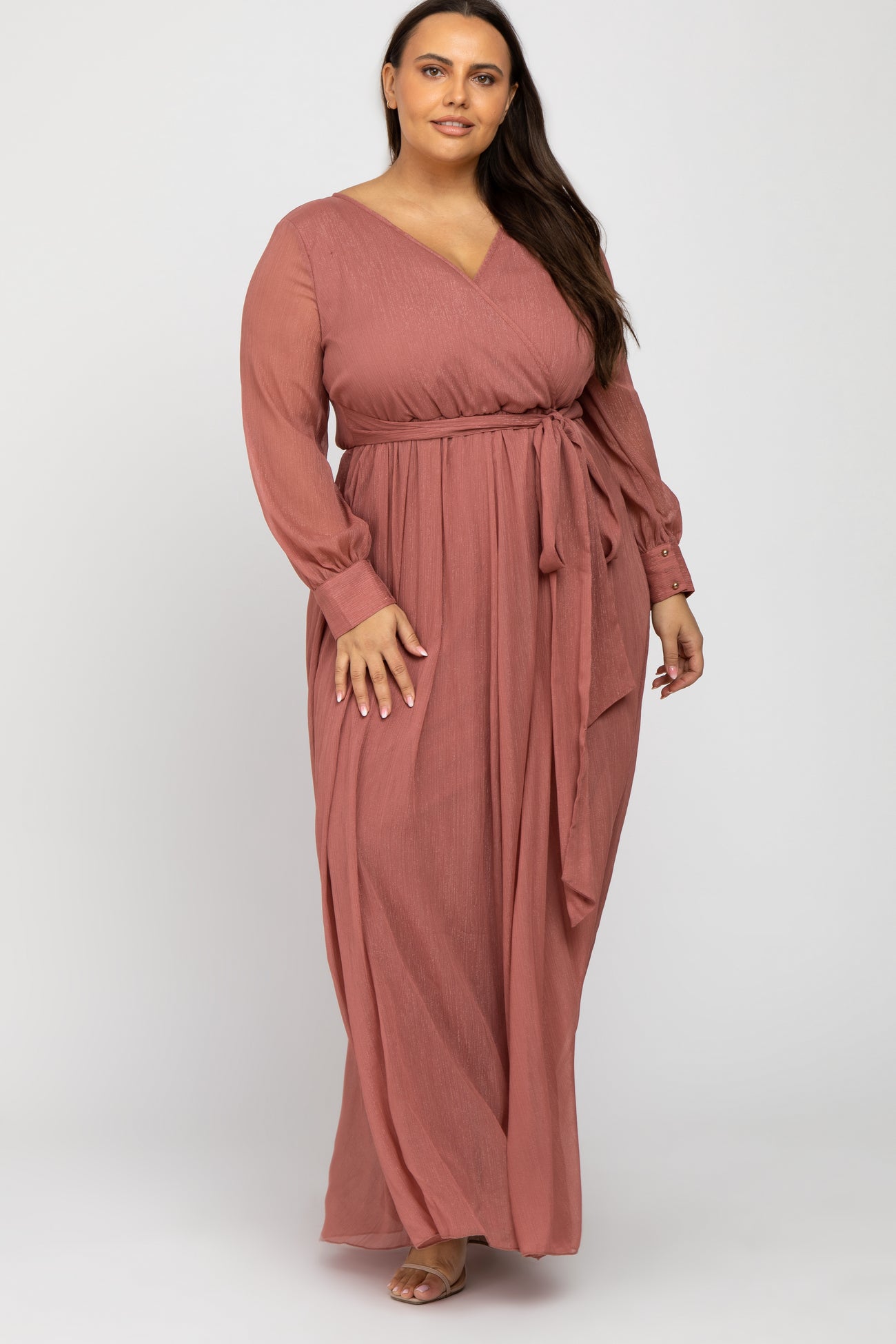 woman wearing a dusty rose long sleeve plus size maxi dress with a wrap tie and v-neckline