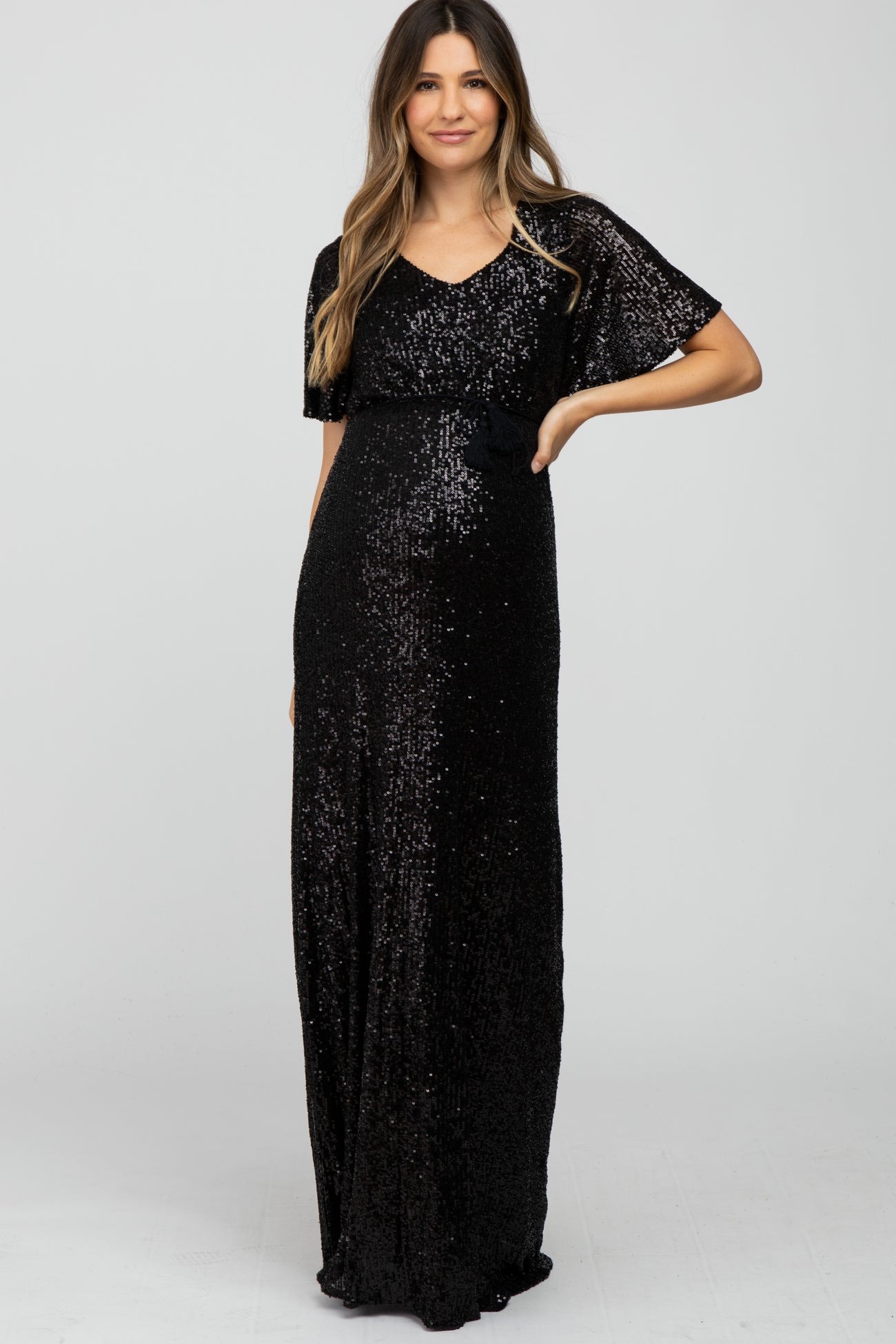 woman wearing a black sequin maxi dress with short sleeves and a fitted waist, showing her baby bump