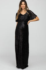 woman wearing a black sequin maxi dress with short sleeves and a fitted waist, showing her baby bump