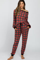woman wearing a red and black plaid maternity pajama set with an off-the-shoulder top and pants