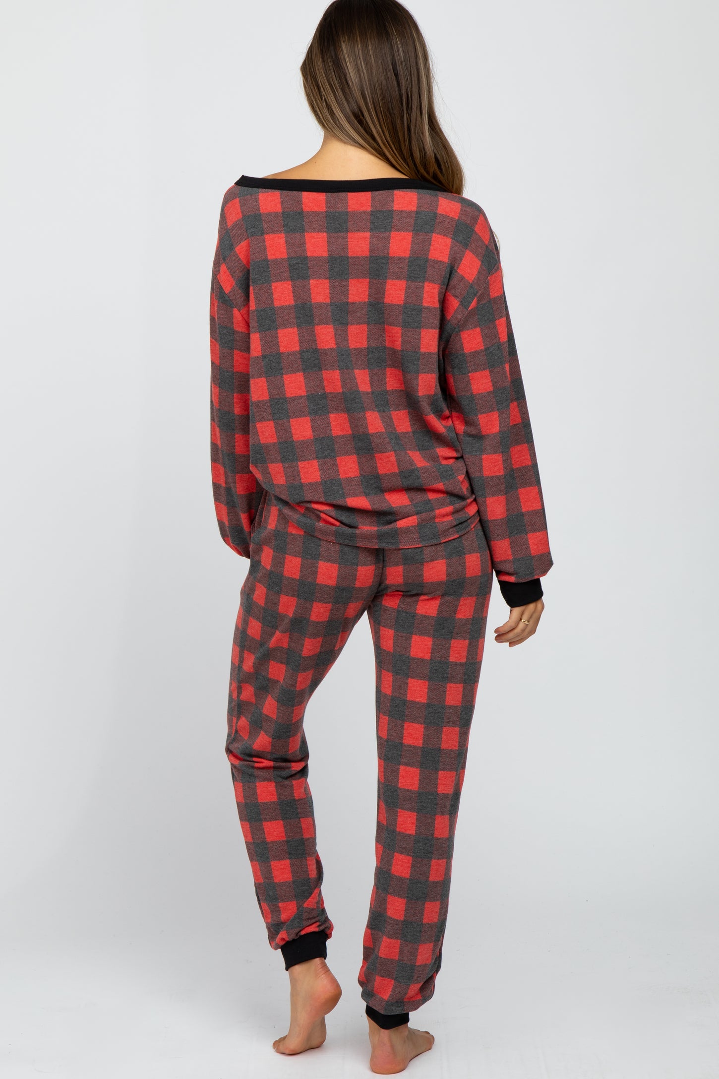 woman wearing a red and gray plaid maternity pajama set viewed from the back