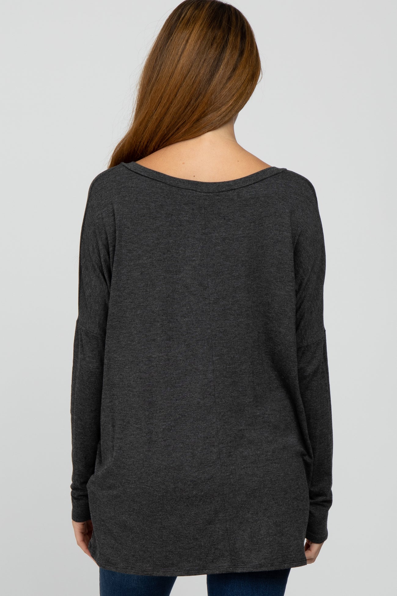woman wearing a dark gray long sleeve maternity top, viewed from the back