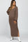woman wearing a brown ribbed maternity maxi dress with long sleeves and side slits, showcasing her baby bump