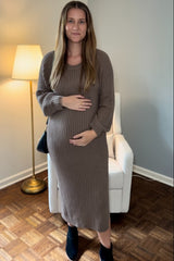 woman wearing a ribbed brown maternity sweater dress and holding her baby bump