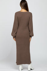 woman wearing a brown ribbed maternity dress with long sleeves and a fitted bodice, seen from the back