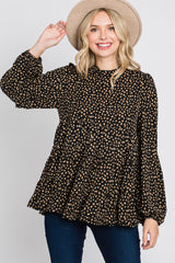 woman wearing a black and gold polka dot long sleeve peplum top with a high neckline and a wide-brimmed hat