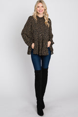woman wearing a black polka dot peplum top paired with dark skinny jeans and over-the-knee black boots