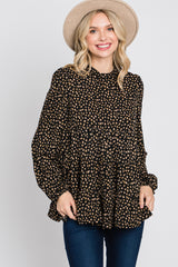 smiling woman wearing a black and tan leopard print tiered tunic top and a beige wide-brimmed hat