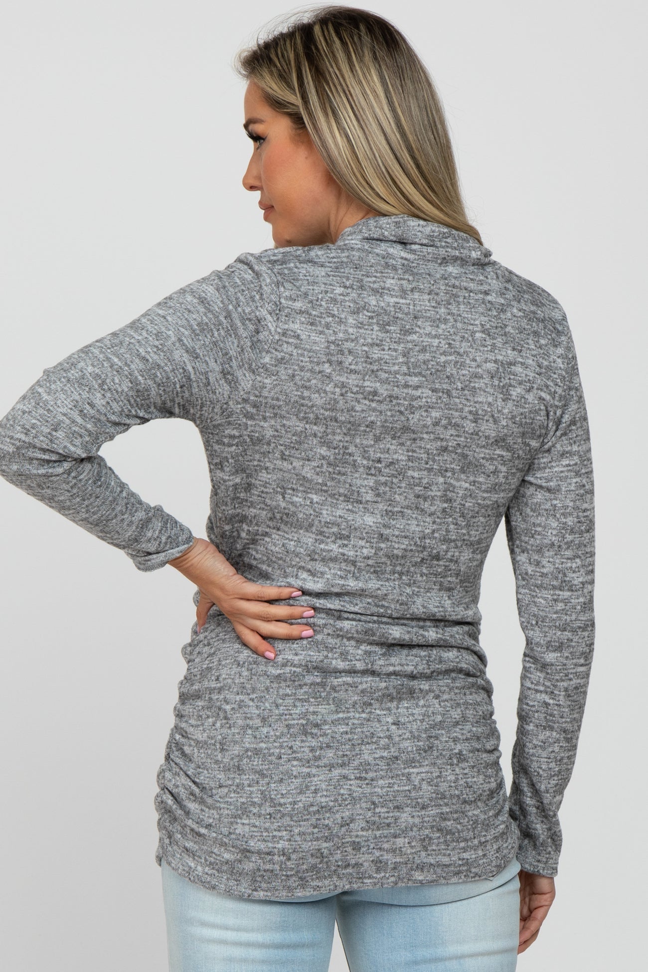woman wearing a gray maternity long sleeve top with a fitted design and gathering detail at the sides