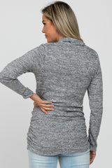 woman wearing a gray maternity long sleeve top with a fitted design and gathering detail at the sides