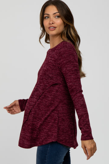 woman wearing a burgundy long sleeve maternity top with textured fabric and a relaxed fit, showcasing her baby bump