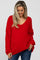 woman wearing a red oversized v-neck maternity sweater with long sleeves and a relaxed fit