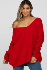 woman wearing a red oversized off-the-shoulder sweater with long sleeves and a relaxed fit