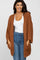 woman wearing an oversized rust-colored fuzzy cardigan over a white top and blue jeans