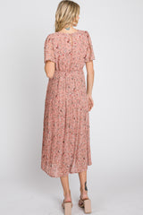woman wearing a pink floral pleated midi dress with short sleeves, view from the back