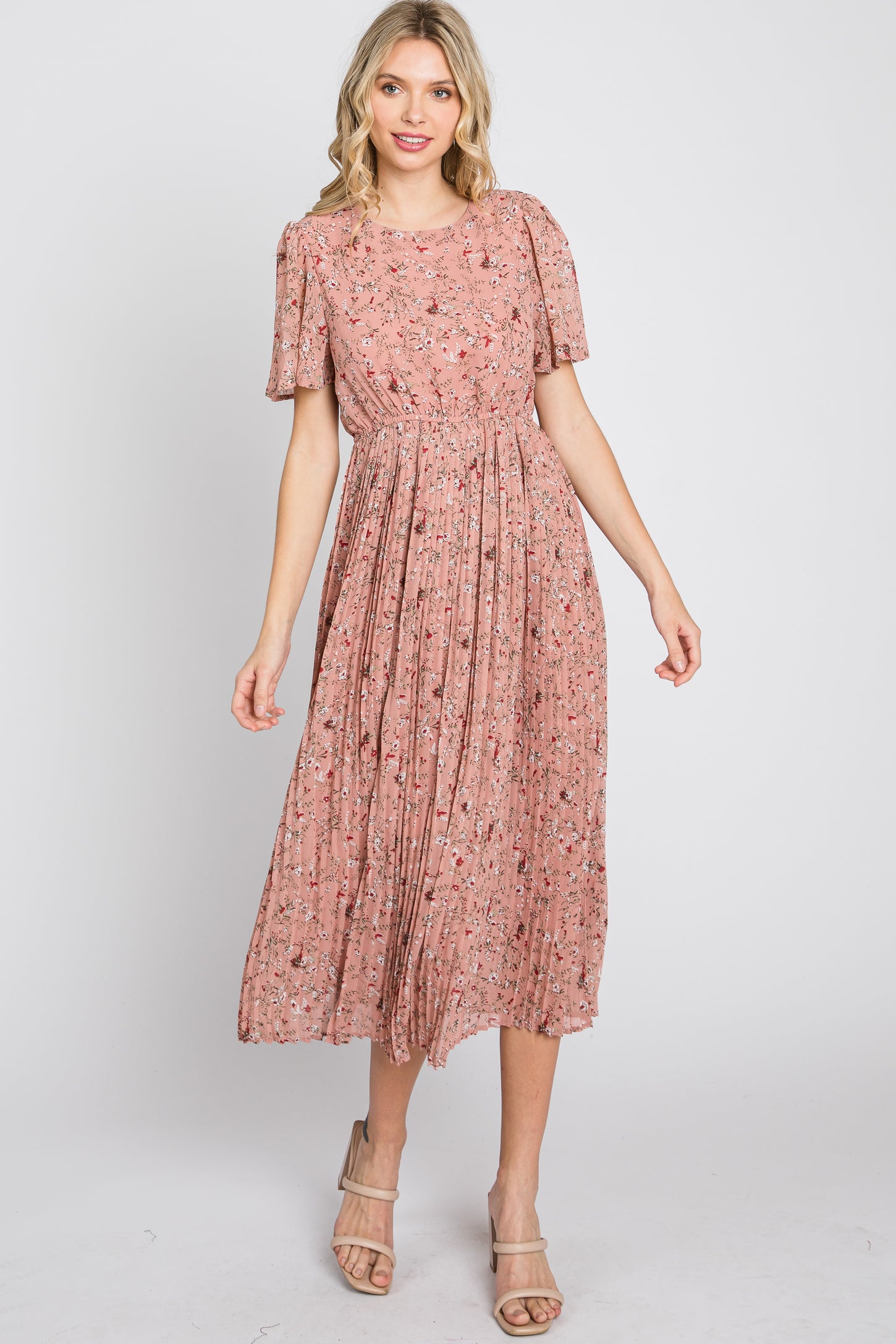 woman wearing a pink floral midi dress with short sleeves and pleated skirt