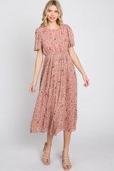 woman wearing a pink floral midi dress with short sleeves and pleated skirt