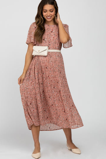 woman wearing a pink floral pleated midi dress with a white belt bag and cream pointed toe flats