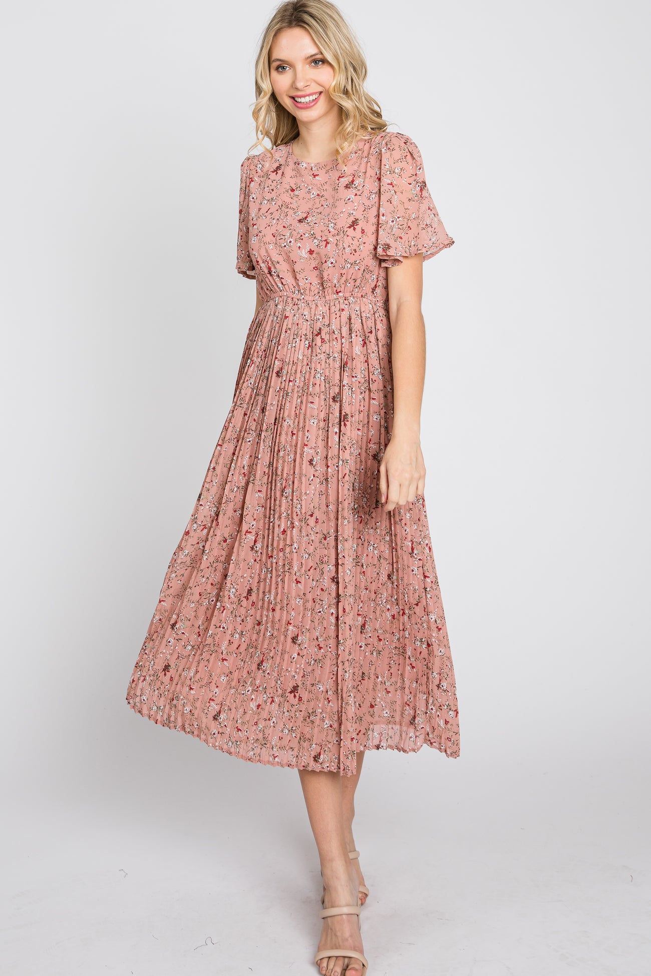 woman wearing a pink floral midi dress with short sleeves and pleated skirt