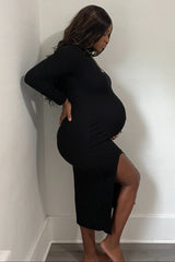 woman wearing a black long sleeve maternity dress with a side slit and visible baby bump