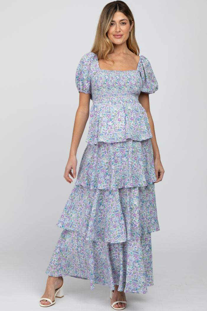 Woman wearing a purple and blue floral tiered maxi dress with puff sleeves and a smocked bodice