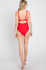 woman wearing a red one-piece swimsuit with a back cutout and adjustable straps, seen from behind