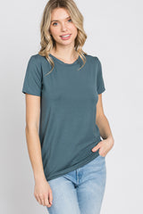 woman wearing a teal short sleeve t-shirt paired with light blue jeans